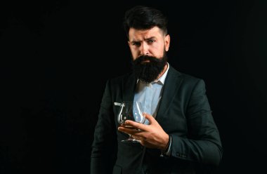 Sommelier pahalı alkol içecek tadı. Yakışıklı sakallı işadamı pahalı konyak içiyor. Viski barda Çekici Barmen