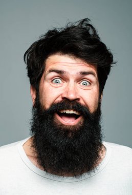 Heyecanlı, yakışıklı bir genç. Gri duvara karşı memnun iş adamının portresi. Olumlu insan yüz ifadeleri ve duyguları