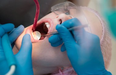 Yakın çekim dişçi klinikte bir kadın hastaya portresi. Her türlü ofiste diş hastalıkları tedavi etmek için özel ekipman vardır