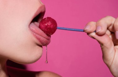 Licking tongue lips. Girl with sexy mouth eating chupa chups close up. Woman lips sucking lollypop. Oral sex blow job concept. Woman holding lollipop in mouth, close up. Red lips, sensual and sexy clipart