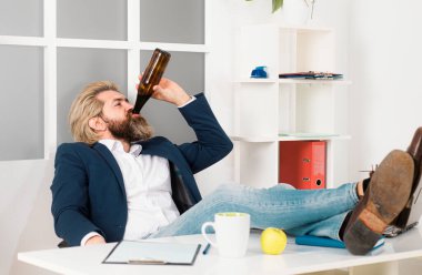 Bağımsız hipster, ofis çalışanı, iş adamı son teslim tarihinden önce işi bitiren, iş gününün sarhoş sonu. İşadamı masa başında içki içiyor.