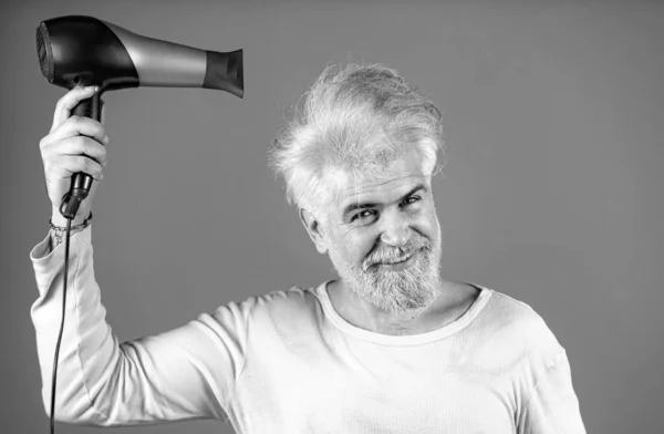 stock image Handsome redhead man with long hair dries his hair with a hairdryer. Blonde man with hair dryer