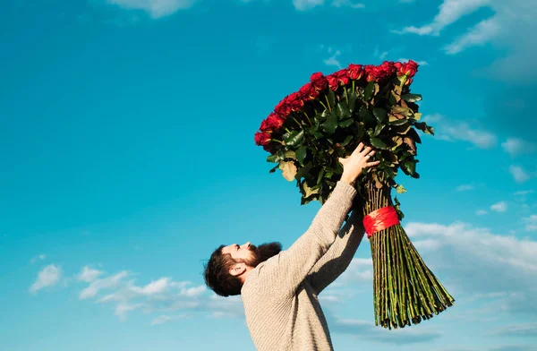 头戴红玫瑰花束的男人 情人节 带着爱的礼物 背景天空中英俊的男人 情人节送的礼物 — 图库照片