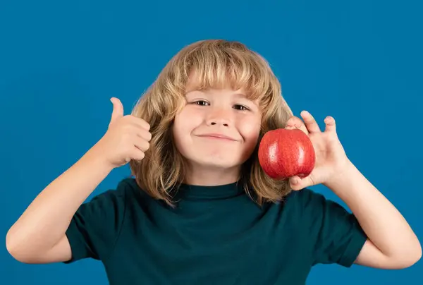 Başparmakları Havada Elma Yiyen Bir Çocuk Mavi Arka Planda Tek — Stok fotoğraf