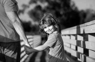 Baba, çocuğun elini tutuyor. Ebeveynlik kavramı