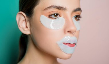 Doğal makyajlı sağlıklı güzel bir kız cildini rutin ve taze göstermek için göz ve dudak için kolajen yakalar. Cilt bakımı yapan güzel modelin yakın portresi