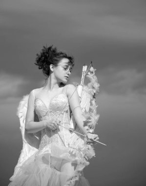 Ok atan Valentin genç kız atışa hazır. Gökyüzünde tüyleri olan sevimli melek ergen. Sevgililer Günü