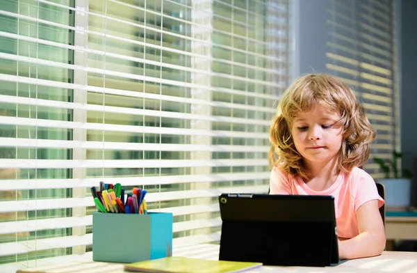 机の上にタブレットを使ってる可愛い子だ オンライン教育の概念 子供の教育知識 — ストック写真