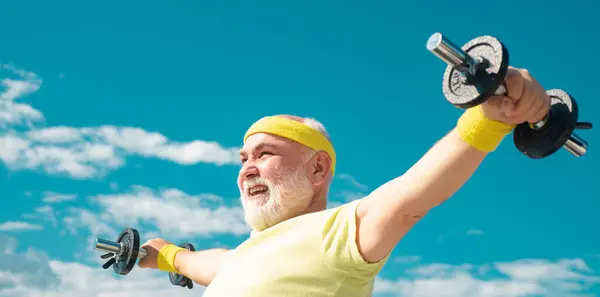老年人举起哑铃 老年人健康快乐微笑的画像 体育中心的资深运动员 老年人在70多岁时训练和举重 喜欢运动 — 图库照片