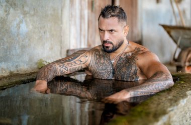 Çiftçi adam çiftlikte yıkanıyor. Doğada yıkanan adam, sağlıklı adam. Çevrede özgürlük. Çıplak gövdeli bir eko adam açık havada banyo küvetinde yıkanıyor. Eko yaşam tarzı. Güçlü vücut, kaslı adam.