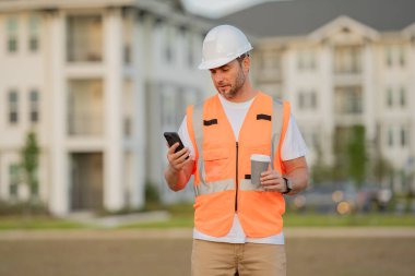Mühendisler molada kahve içerek kahve alırlar. İnşaat alanındaki bir inşaatçının portresi. İnşaatçı yeni ev inşa etmeye hazır