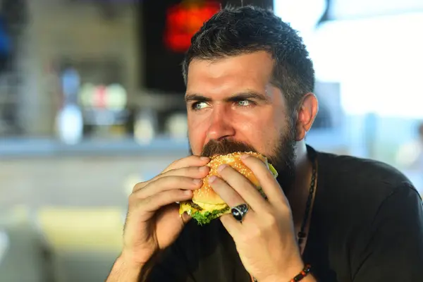 Hunger Man eat burger. Man eat tasty Hamburger. Dinner with Hamburger. Hamburger on lunch. Delicious gourmet. Cheeseburger or hamburger, burger sandwich. Food, meal. Man eating tasty burger