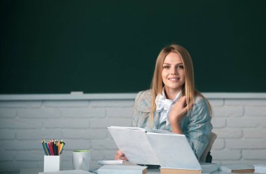 Sınava hazırlanan, elinde kitap tutan ve okuyan kız üniversite öğrencisi.