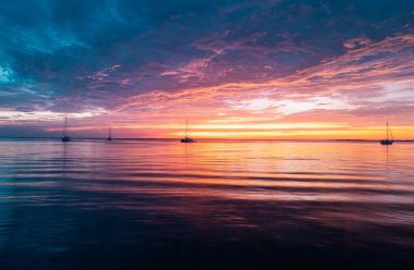 Altın dramatik gökyüzü manzaralı deniz üzerinde gün batımı. Gün batımı gökyüzü olan sakin bir deniz. Okyanus ve gökyüzü arkaplanı