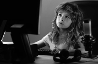 Zeki çocuklar çevrimiçi evde öğreniyor. Beyaz çocuk geceleri karanlık odada dizüstü bilgisayarla çalışıyor. Okul, eğitim, online öğrenme konsepti. Klavyede yazan öğrenci.