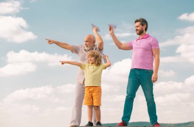 Büyükbaba ve oğul gökyüzünde oyuncak uçakla oynuyorlar. Mutlu bir aile. Üç erkek nesli. Mutlu bir çocukluk. Başlangıç, yaratıcılık başlangıç konsepti