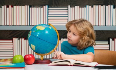 İlkokulun kütüphanesindeki küreye bakan bir öğrenci. İnek okulu çocuğu. İlkokuldan zeki bir çocuk. Zeki dahi zeki çocuk öğrenmeye hazır. Dünya küresi