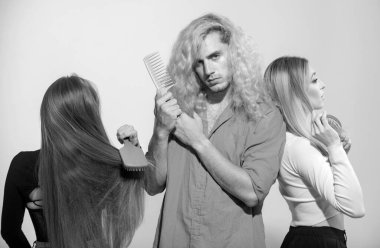 Saçlarını tarayan bir grup genç kadın ve erkek. İnsanlar saç tarıyor, kızlar ve erkekler saç tarıyor, bakım prosedürleri uyguluyor.