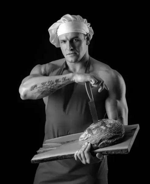 料理とベーキング エプロンのパン屋さん セクシー男とともにパンとナイフ — ストック写真