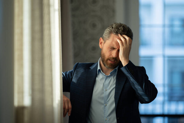 Головные боли, усталость и стресс. У человека в костюме крупным планом мигрень. Концепция головной боли. Больные мужчины испытывают стресс на работе. Стресс и головная боль