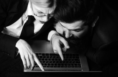 Dizüstü bilgisayar kullanan bir çift. Dizüstü bilgisayarla çalışan iki ortak. Küçük iş adamları birlikte dizüstü bilgisayara bakıyorlar.