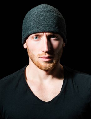 Acımasız bir adam, yakışıklı, ciddi bir erkek model. Siyahların üzerinde ciddi profil yüzü olan bir adamın yakın portresi.