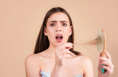 Saçını taramış, saçları sorunlu bir kadın. Saç dökülmesi stresli kadın ve kel problemleri