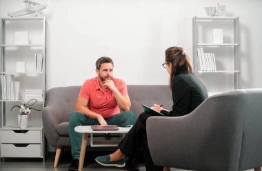 Orta yaşlı adam sorunu terapisi. Yakışıklı adam kanepede oturuyor ve psikologla konuşuyor. Psikoloji hastası psikolojik danışmanlık sırasında akıl sağlığından bahsediyor.