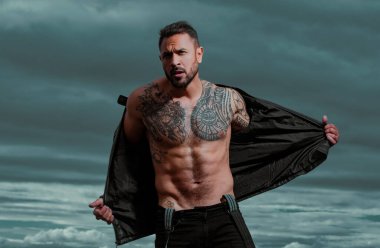 Kendine güvenen, çekici, seksi adam. Deri ceketli, modacı erkek model.