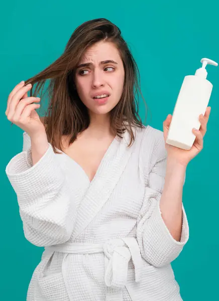 伤心的女孩看着她受损的头发 女人拿着瓶子洗发水和护发素 妇女触摸头发 脱发或头皮干燥问题 — 图库照片