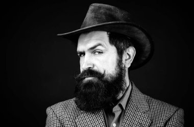 Geçmişi olan yakışıklı bir adam, siyah arka planda ciddi sakallı bir hippinin portresi.