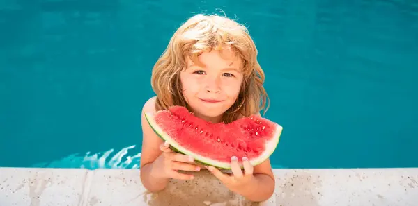 Kid eats watermelon in the pool. Cute boy eating slice of red watermelon on the beach, happy caucasian boy watermelon against the blue water
