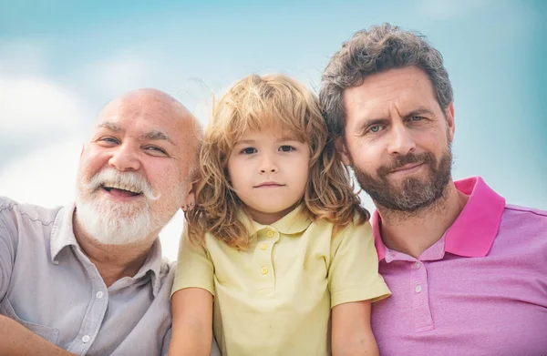 Boy son with father and grandfather, outdoor close up portrait. Fathers day. Men in different ages