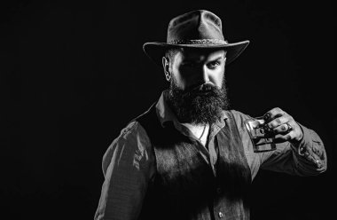 Barmen elinde bir bardak viski tutuyor. Tatma ve degukasyon konsepti. Viski ya da viskili antika bir adam. Barmen deri önlüğü bardakta viski kokteyli tutuyor.