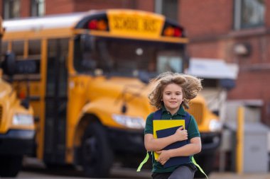 Okul çocuğu okul otobüsüne biniyor. Amerikan Okulu. Okula dönelim. İlkokulun çocuğu. Mutlu çocuklar çalışmaya hazır. Eğitici kavram