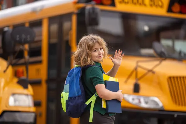 Pupil with backpack and book getting on the school bus. American School. Back to school. Bye bye. Kid of primary school. Happy children ready to study