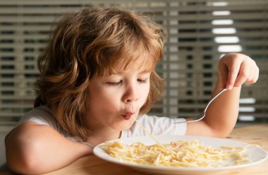 Makarna ve spagetti yerken yakın çekim. Çocuk yüzü, küçük çocuk portresi.