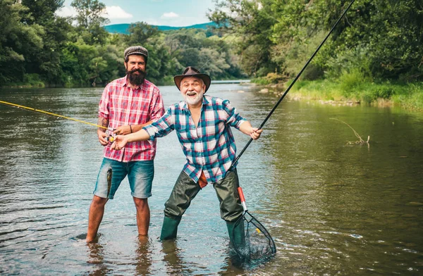 Men hobby and recreation. Fishermen successful catch fish. Fisher retirement. Retired businessman in suit with fishing rod. Male friendship. Granddad and drandson fishing. Happy excited man friends