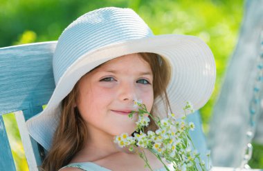 Bahar çocuğu suratı. Bahar çiçekli küçük sarışın bir kızın portresi. Arka bahçedeki komik çocuklar. Çocuklar çiçek arkaplanda yüzlerini kapatırlar. Çocuklar bahar çiçeklerinde oynar.