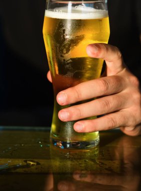Bira bardakları. Adam el ele tutuşup bir bardak bira içiyor.