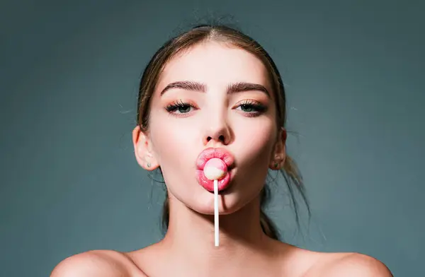 Sensual glamorous attractive lady licking yummy sugary lollypop with red lips. Girl sucks lollipop. Flirting sexy female pop art style. Portrait of sexy woman