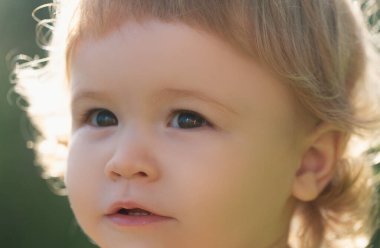 Küçük sarışın bir çocuğun portresi, yakın plan. Kesik suratlı şirin çocuklar. Pozitif duygusal Bebek