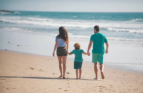 在海滩上的快乐家庭的回顾 人们在暑假玩得很开心 母亲和孩子手牵着手面对蓝色的大海 假日旅行概念 — 图库照片