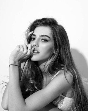 Yatakta battaniyeli ve kameraya bakan neşeli genç bir kadın. Şehvetli kız yatakta uyuduktan sonra kendini zinde hissediyor. Gülen kadın yastık ve battaniyeyi kucaklarken eğleniyor.