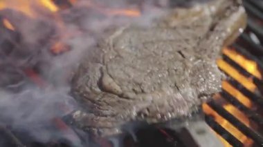 Ateşli ızgara et. Yanan ızgarada ızgara biftek pişiyor. Izgara et. Barbekü mermer bifteği ateşte. Barbeküde alevli biftek. Barbekü ve ızgara. Kızarmış et.