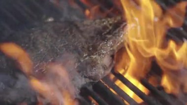 Ateşli ızgara et. Yanan ızgarada ızgara biftek pişiyor. Izgara et. Barbekü mermer bifteği ateşte. Barbeküde alevli biftek. Barbekü ve ızgara. Kızarmış et.