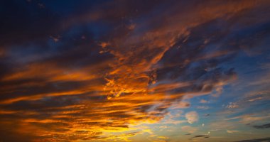 Gün batımı ya da gün doğumu. Dramatik görkemli gün batımı. Gökyüzü bulutlu ve gökyüzü aydınlık arka planda. Farklı şekillerde bulutlarla gün doğumu. Sakin gün batımı gökyüzü ve bulutlar arasında güneş