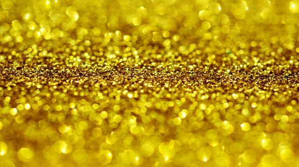 Glitter golden backgrounds. Golden Light bokeh to design. Glitter golden backgrounds for valentines day, birthday or Christmas cards. Golden texture. Light gold bokeh
