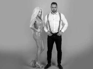 Oyuncak bebek tarzında bir çift. Sevgililer Günü. Birbirine aşık bir çift. Pembe elbiseli romantik moda kadını ve takım elbiseli şık bir adam. Pembe stüdyo arka planı