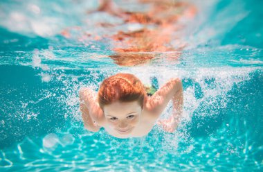 Young boy swim and dive underwater. Under water portrait in swim pool. Child boy diving into a swimming pool